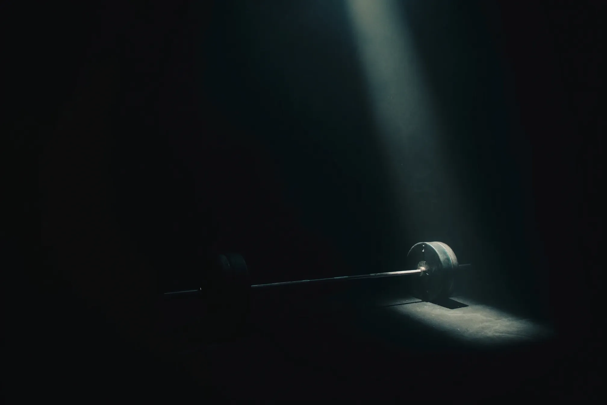 Loaded barbell in a cinematic training hall